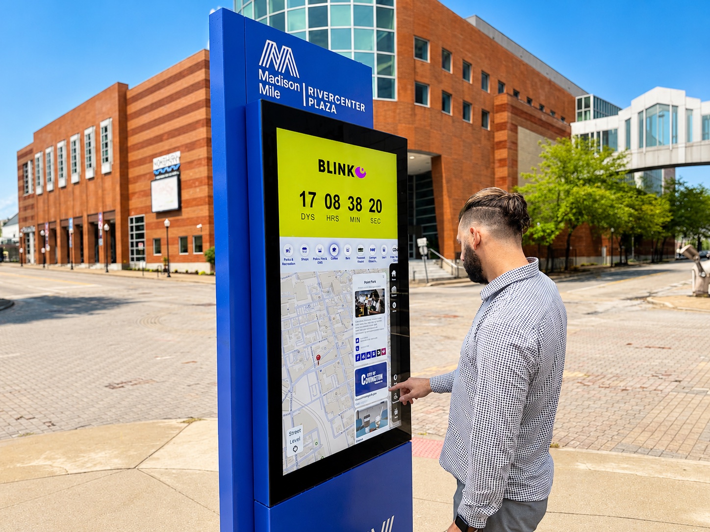 A visitor using a blue Madison RiverCenter kiosk with a map interface